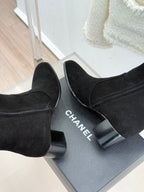Black suede tall boots with block heels; CHANEL text visible on heel