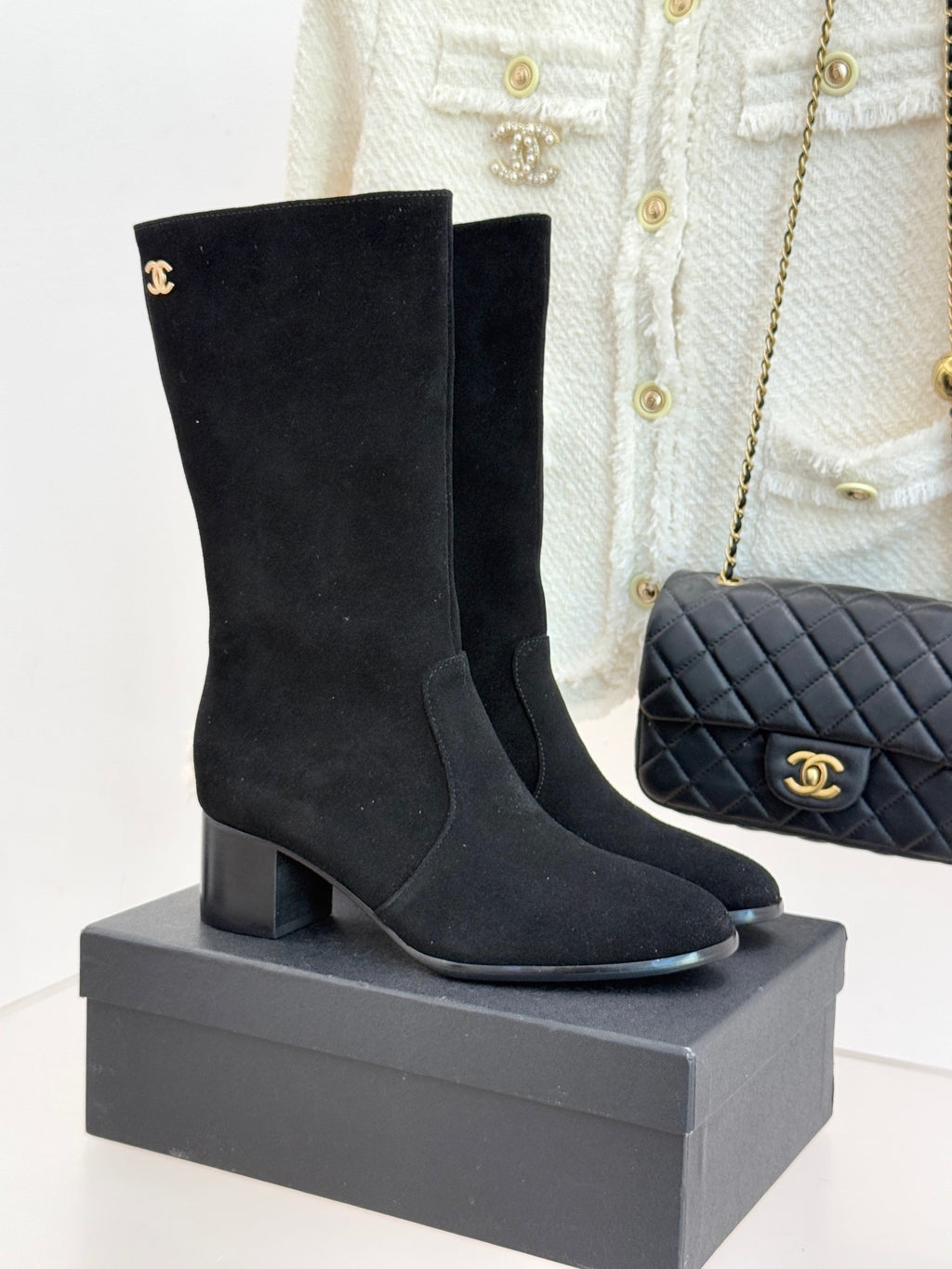 Black suede heeled boots with Chanel CC logo, side zipper, on display box