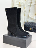 Black suede heeled boots with Chanel CC logo, side zipper, on display box