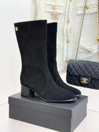 Black suede heeled boots with Chanel CC logo, side zipper, on display box