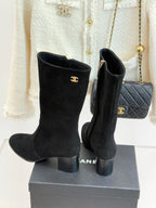 Black suede tall heeled boots with Chanel CC logos, side zippers, on display box
