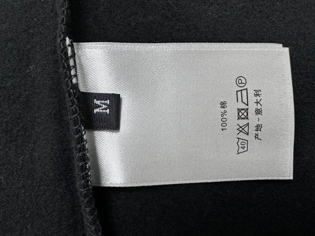 Dior care label on black sweatshirt: 100% cotton, wash and dry symbols