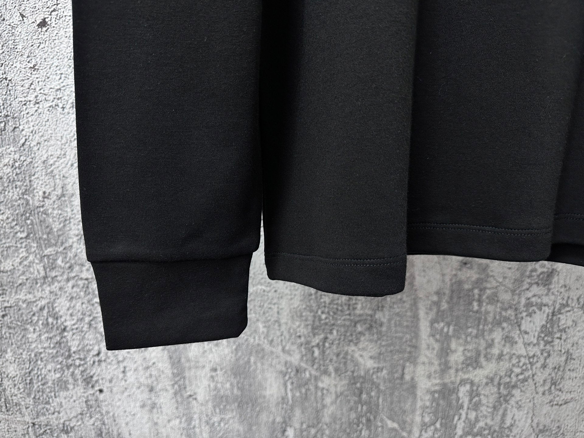 Black sweatshirt hem and ribbed cuffs detail