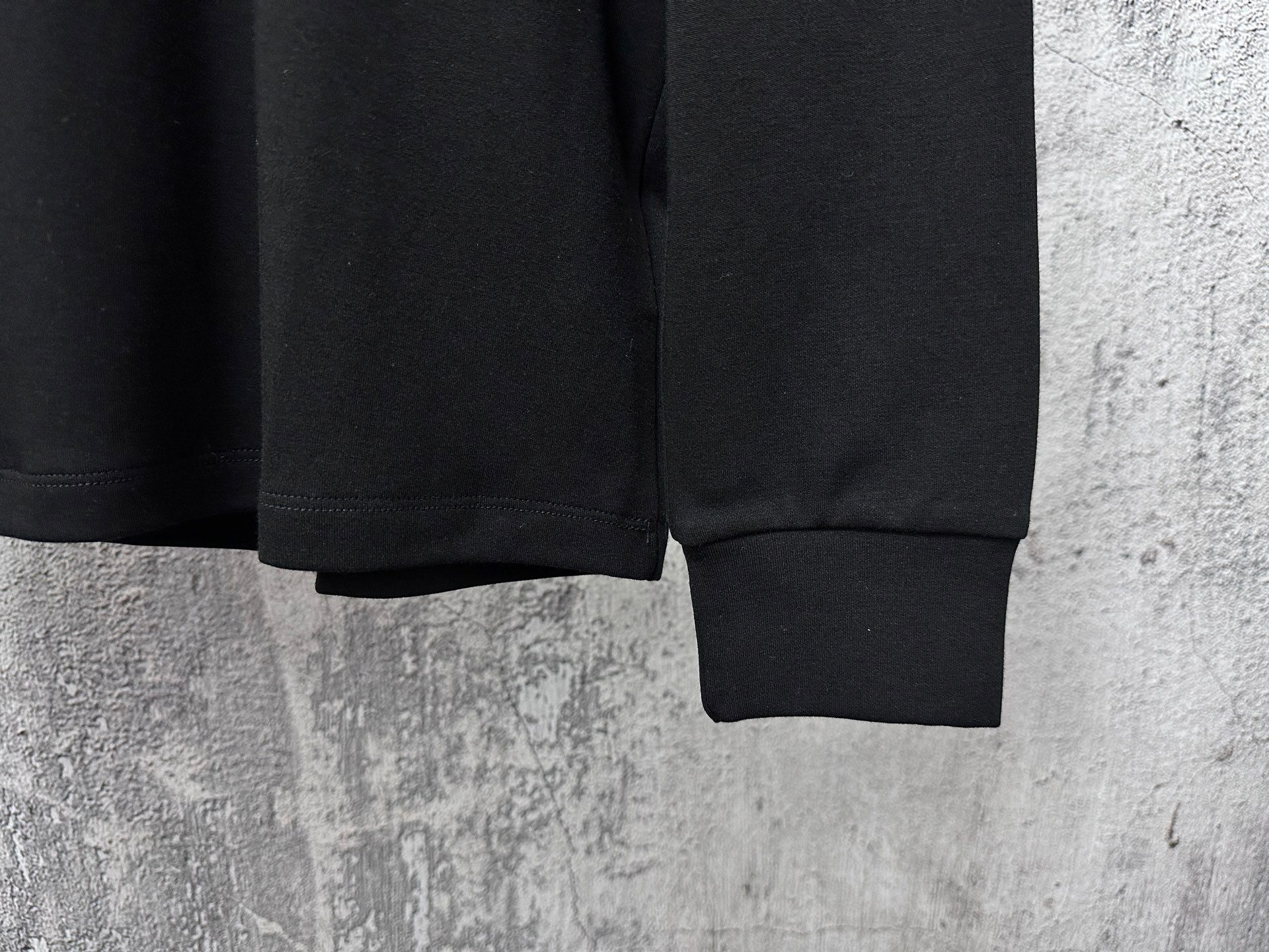 Black Dior crewneck sweatshirt sleeves and ribbed cuffs