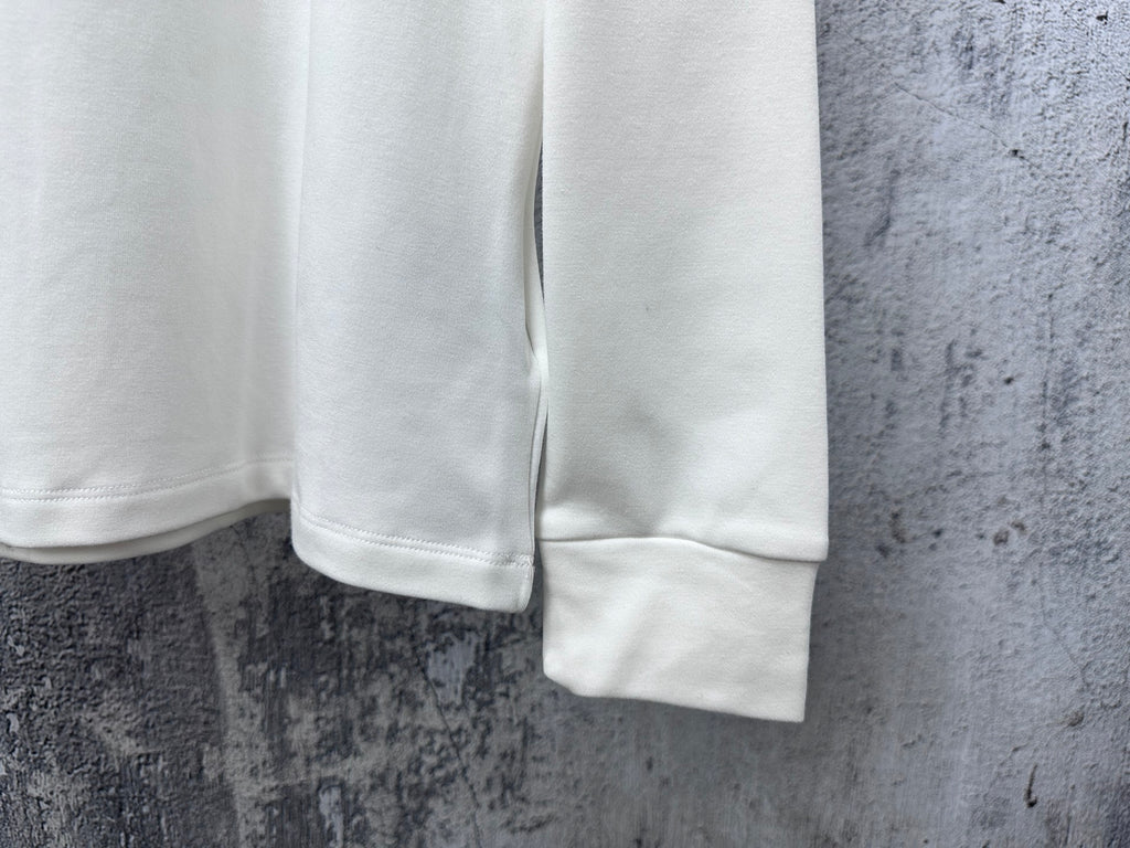 White long-sleeve shirt with ribbed cuffs and straight hem detail