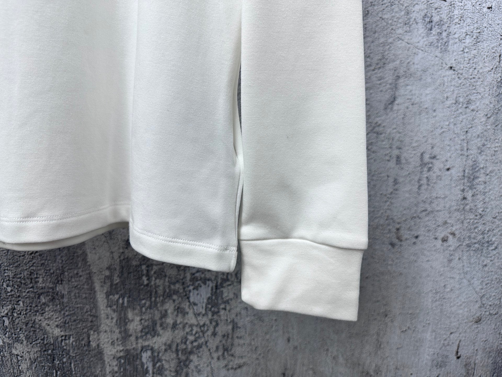 White long-sleeve shirt with ribbed cuffs and straight hem detail