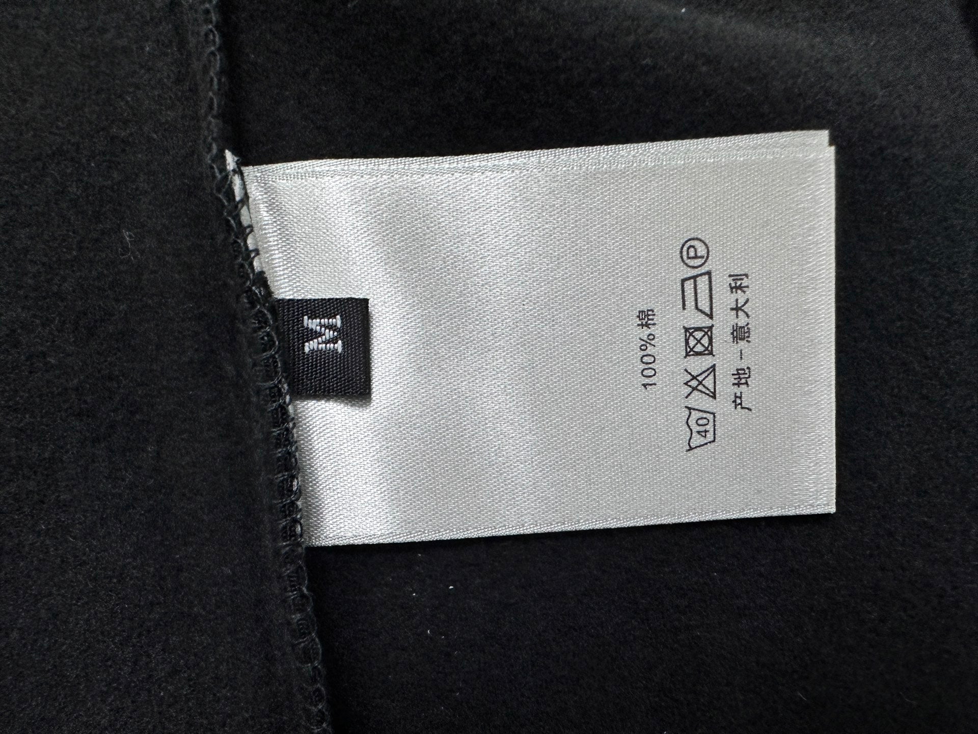 Dior sweatshirt care label on black fabric, 100% cotton
