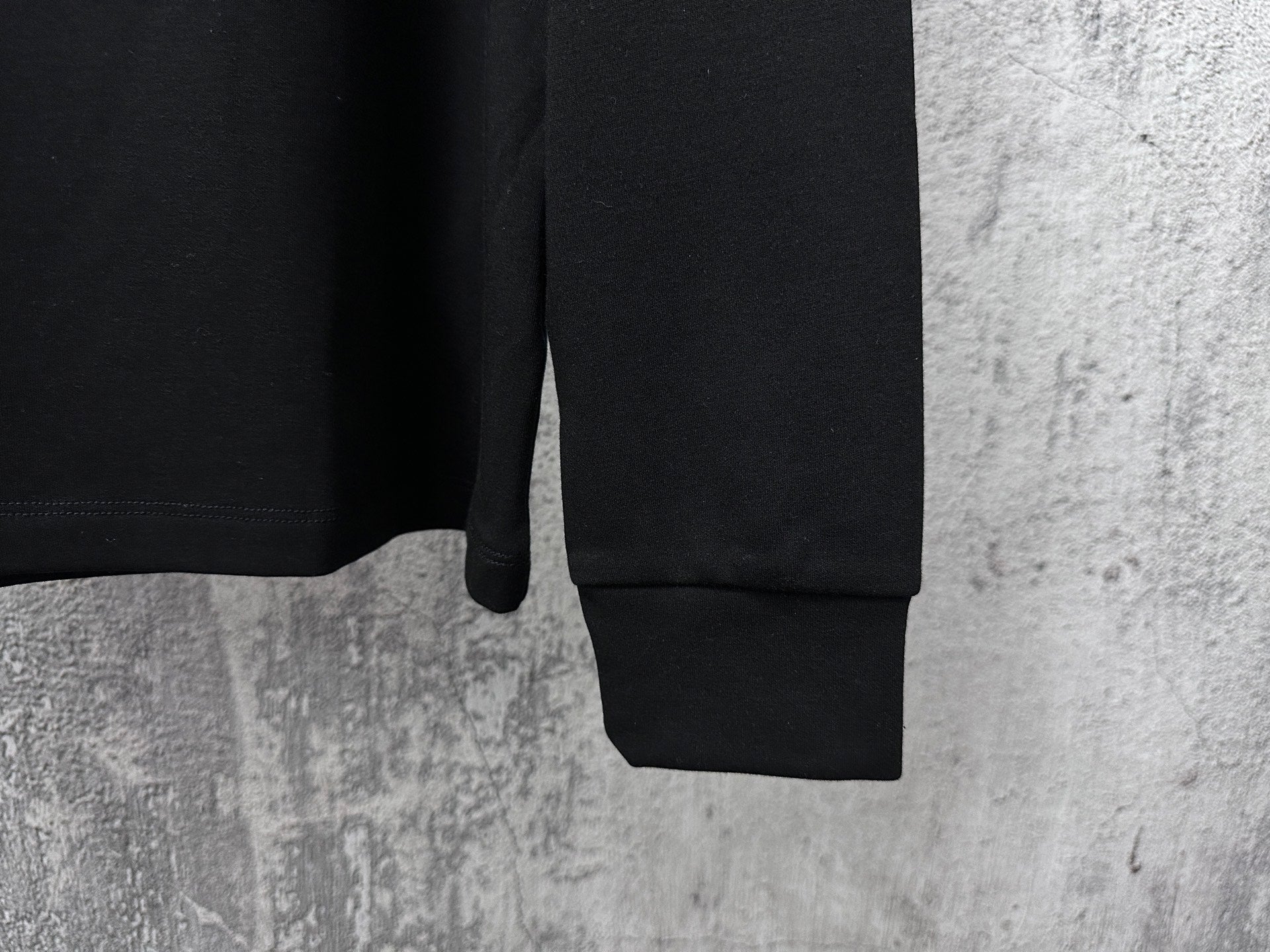 Black long-sleeve sweatshirt with ribbed cuffs and straight hem