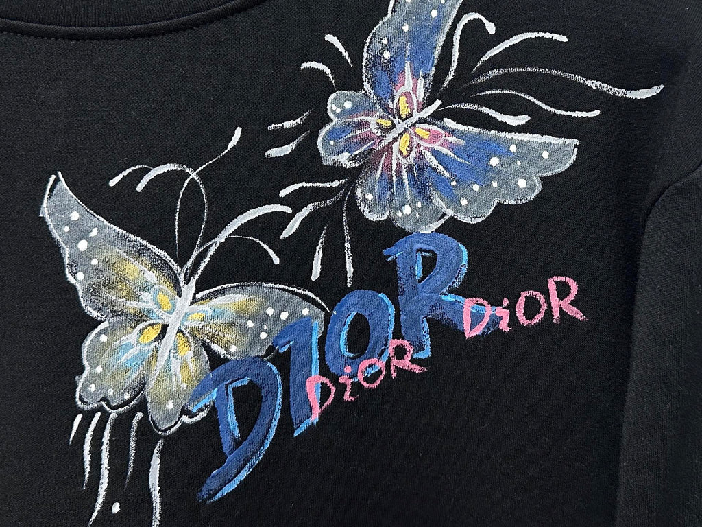 Black sweatshirt close-up of butterfly graphic and Dior lettering