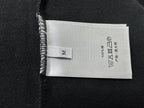 Fabric care label on black sweatshirt tag, 100% cotton