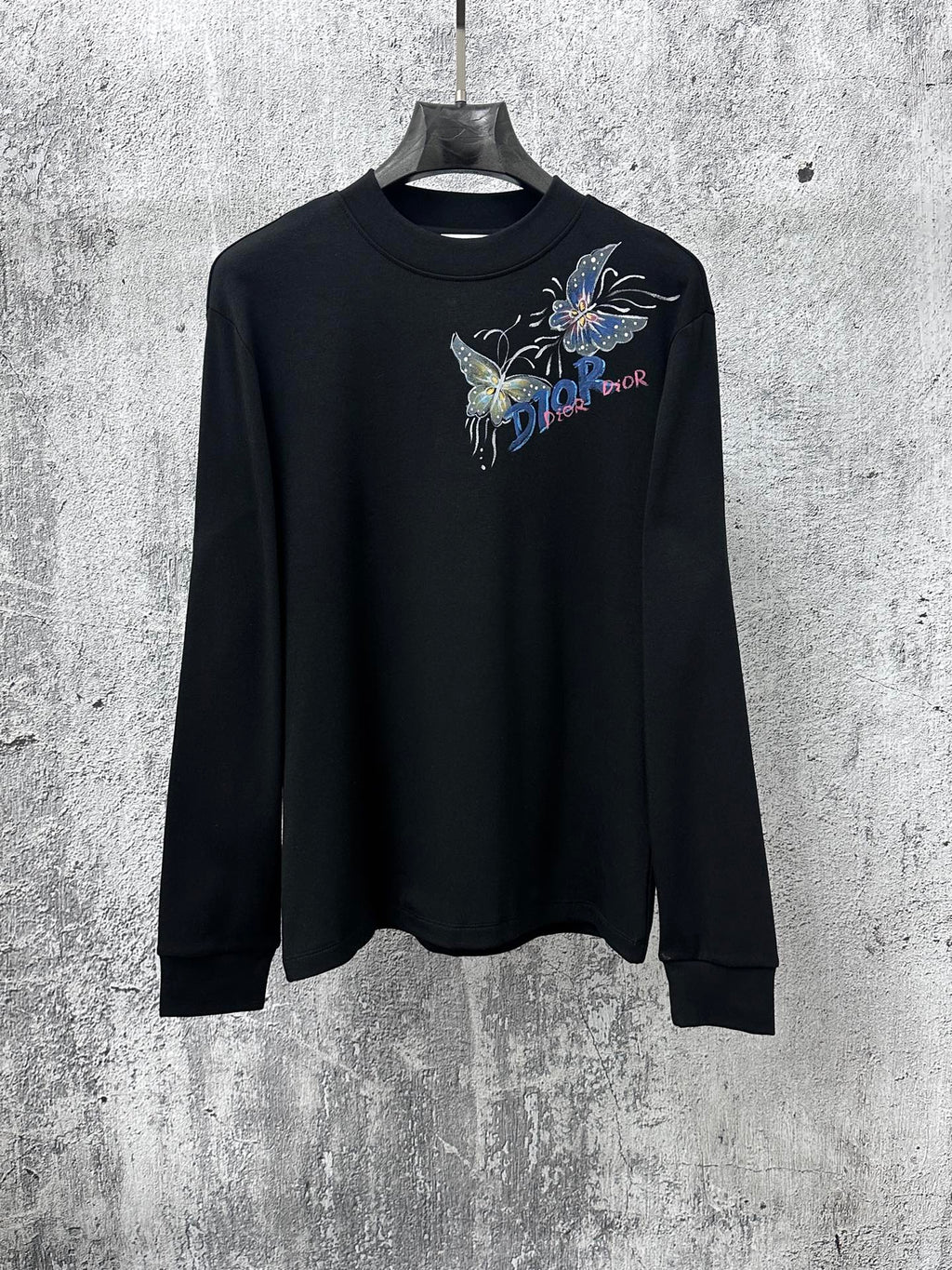 Black long-sleeve sweatshirt with butterfly graphic and Dior logo on chest