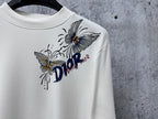 White long-sleeve top with Dior flower and butterfly graphic, crew neckline.