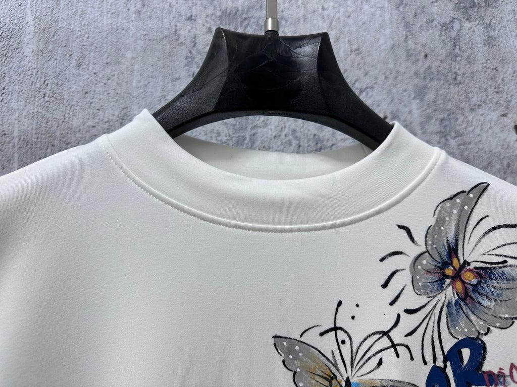White crew-neck sweatshirt with partial Dior floral print detail.