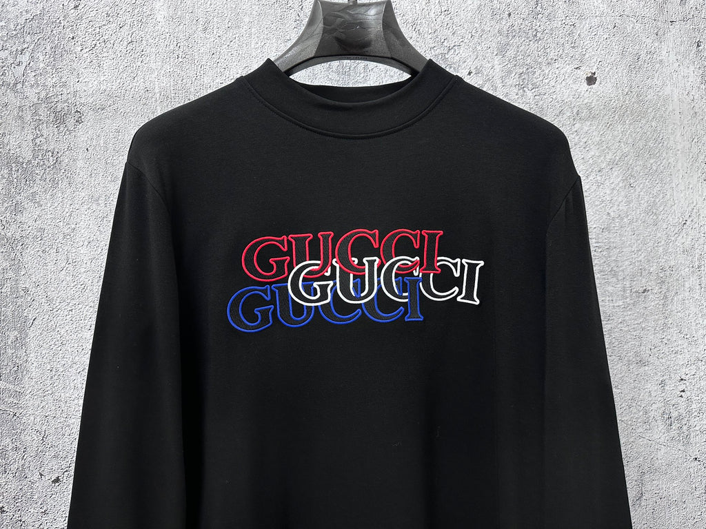 Black long-sleeve crewneck T-shirt with red and blue Gucci logo on chest