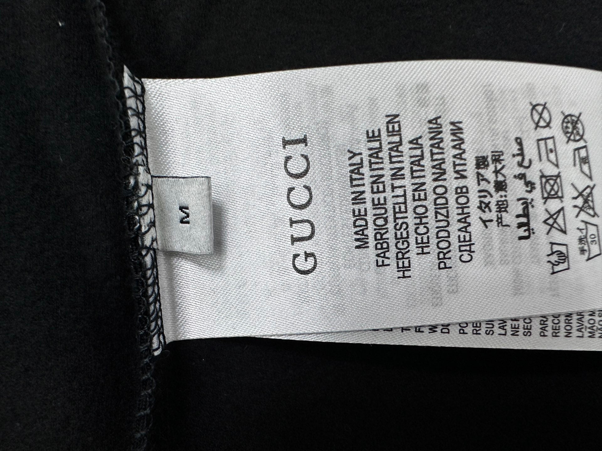 Black T-shirt with Gucci size label and care symbols inside collar