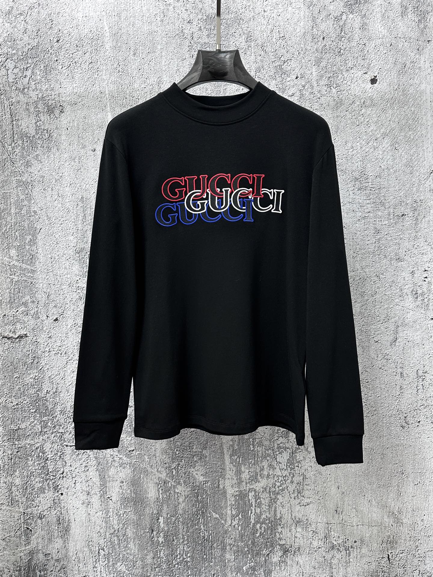 Black long-sleeve crewneck T-shirt with multicolor Gucci logo graphic