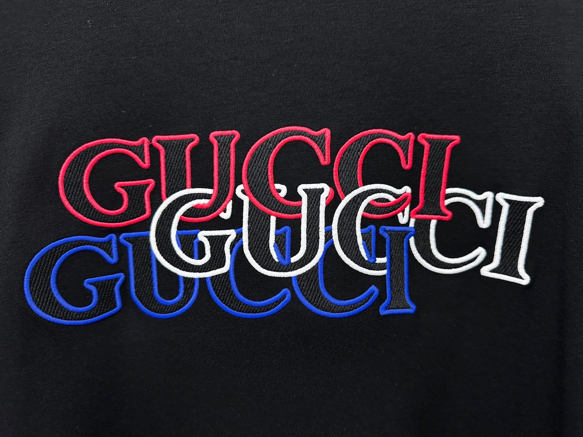 Black long-sleeve T-shirt with large red and blue Gucci logo print