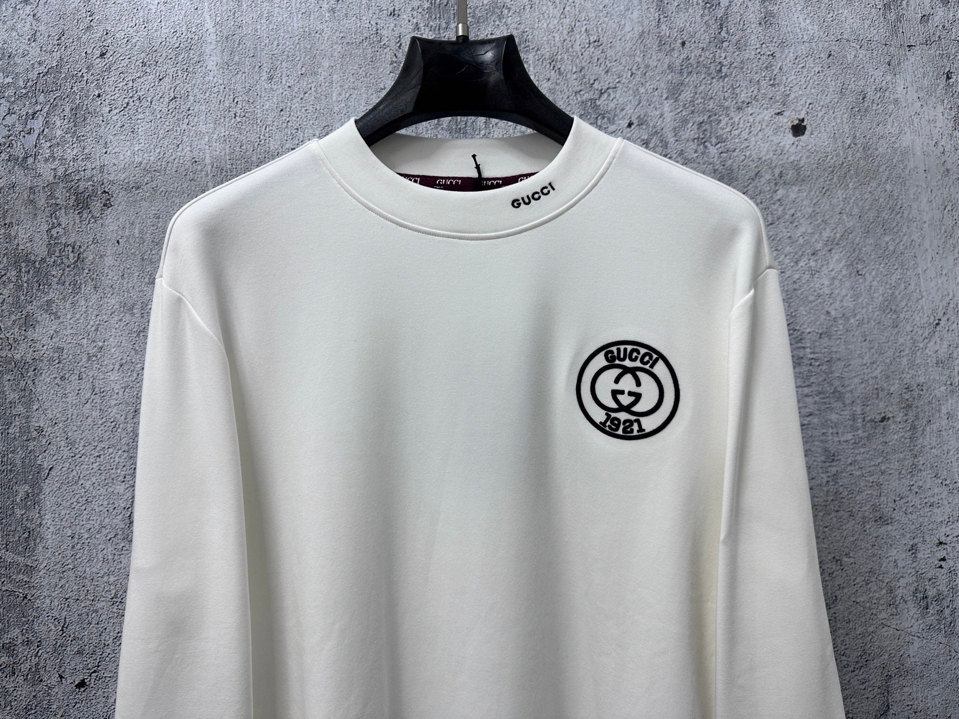 White long-sleeve T-shirt with Gucci round logo patch on left chest