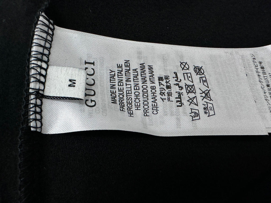 Clothing size label reading M; Gucci and care text inside sweatshirt