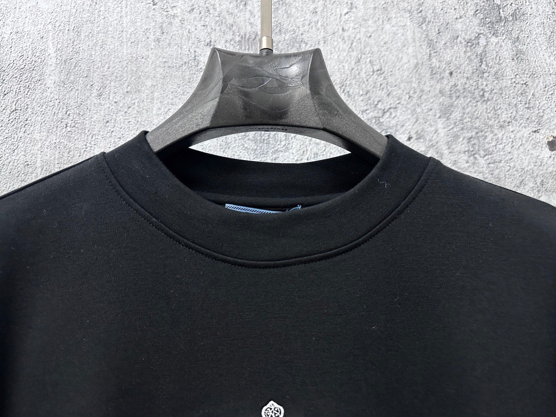 Black long-sleeve sweatshirt crew neck and inner neckline seam detail
