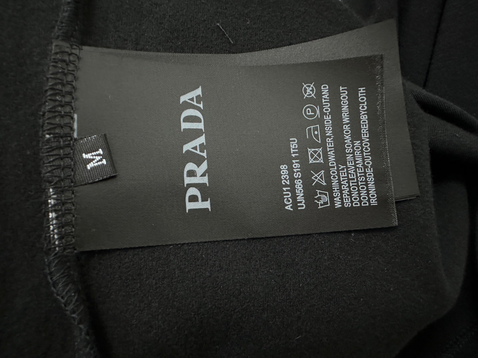 Black sweatshirt with PRADA fabric care label at side seam