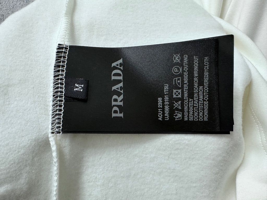 White sweatshirt with black PRADA care label tag inside neckline