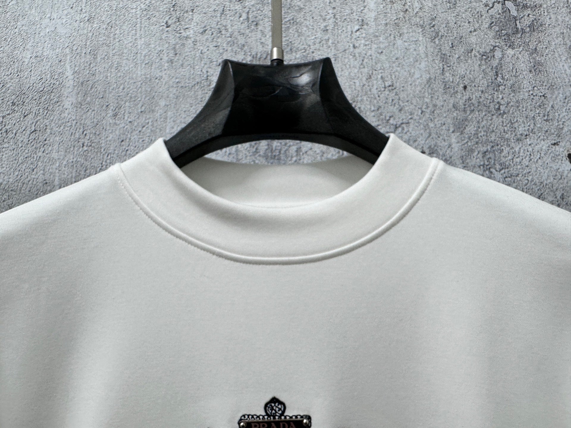 White long-sleeve sweatshirt with ribbed crew neck and small chest logo