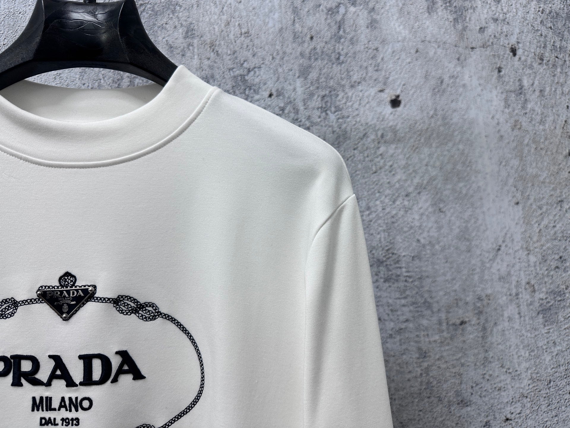 White long-sleeve sweatshirt with PRADA Milano logo close-up