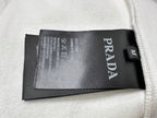 PRADA label tag on inside of cream sweatshirt