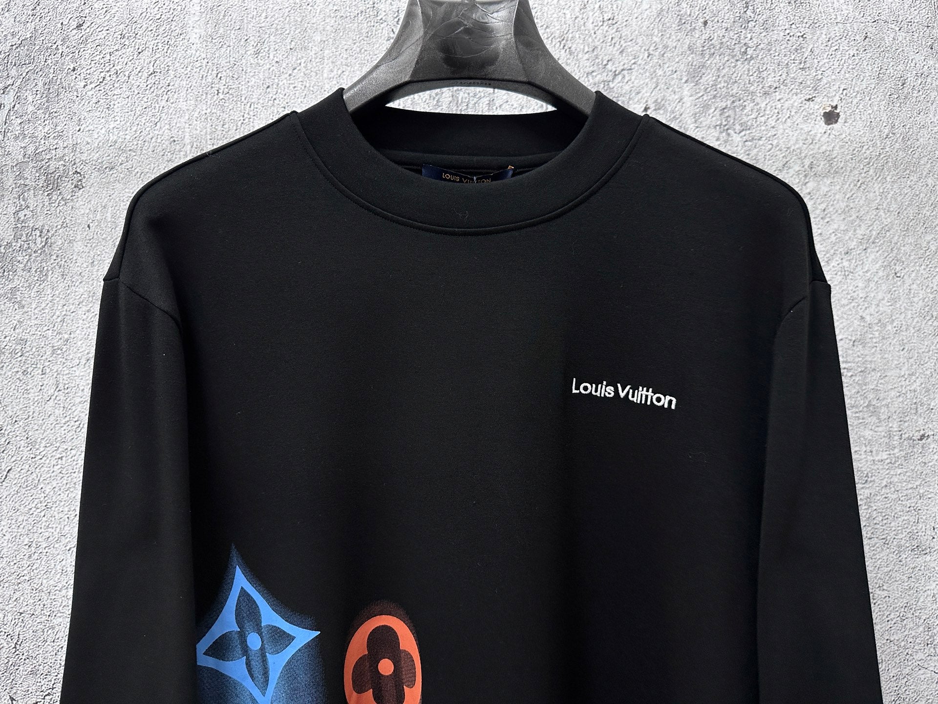 Louis Vuitton long-sleeve sweatshirt front view, black fabric with chest logo and graphic