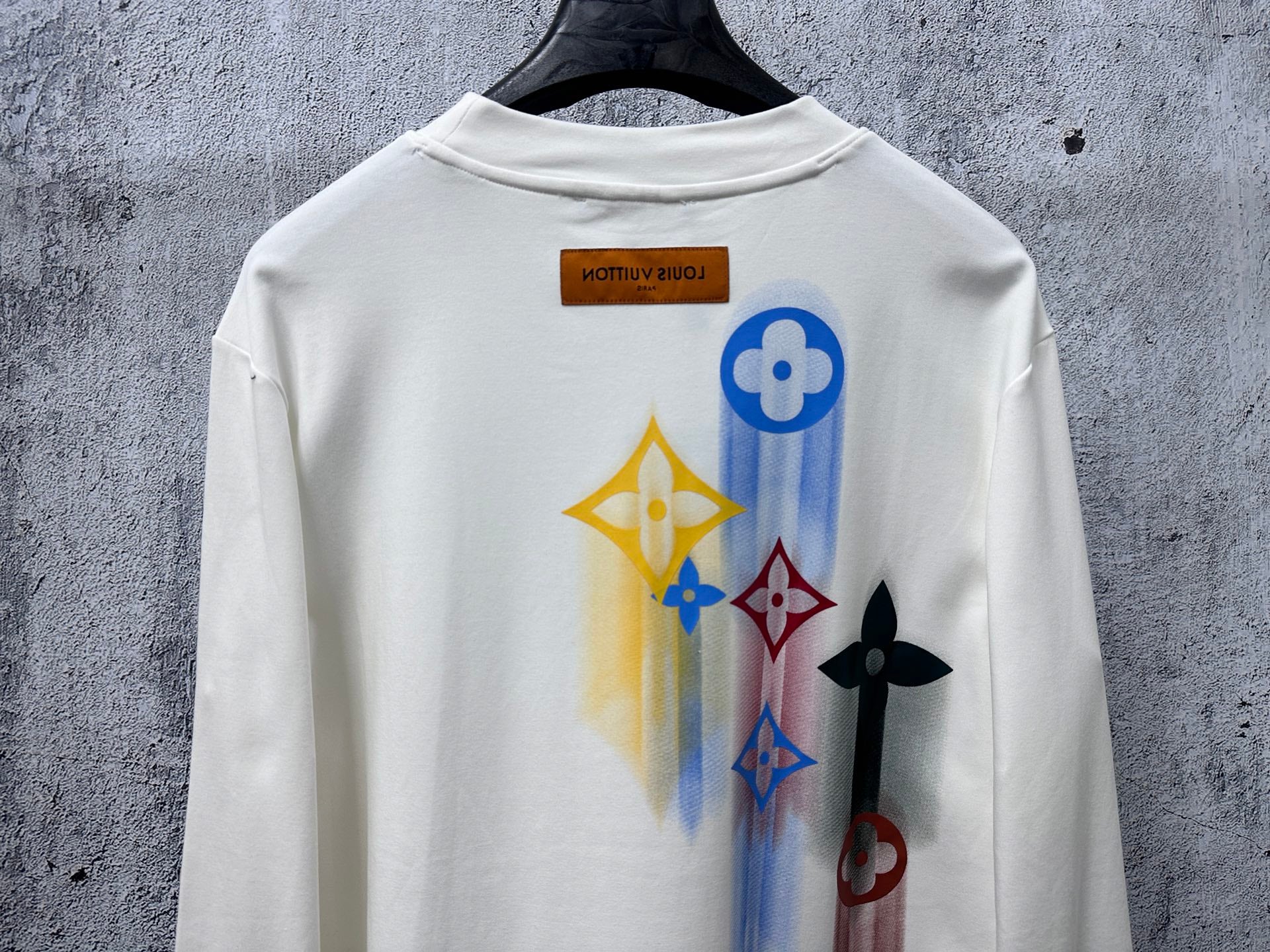 White long-sleeve sweatshirt with large colorful back graphic and Louis Vuitton label