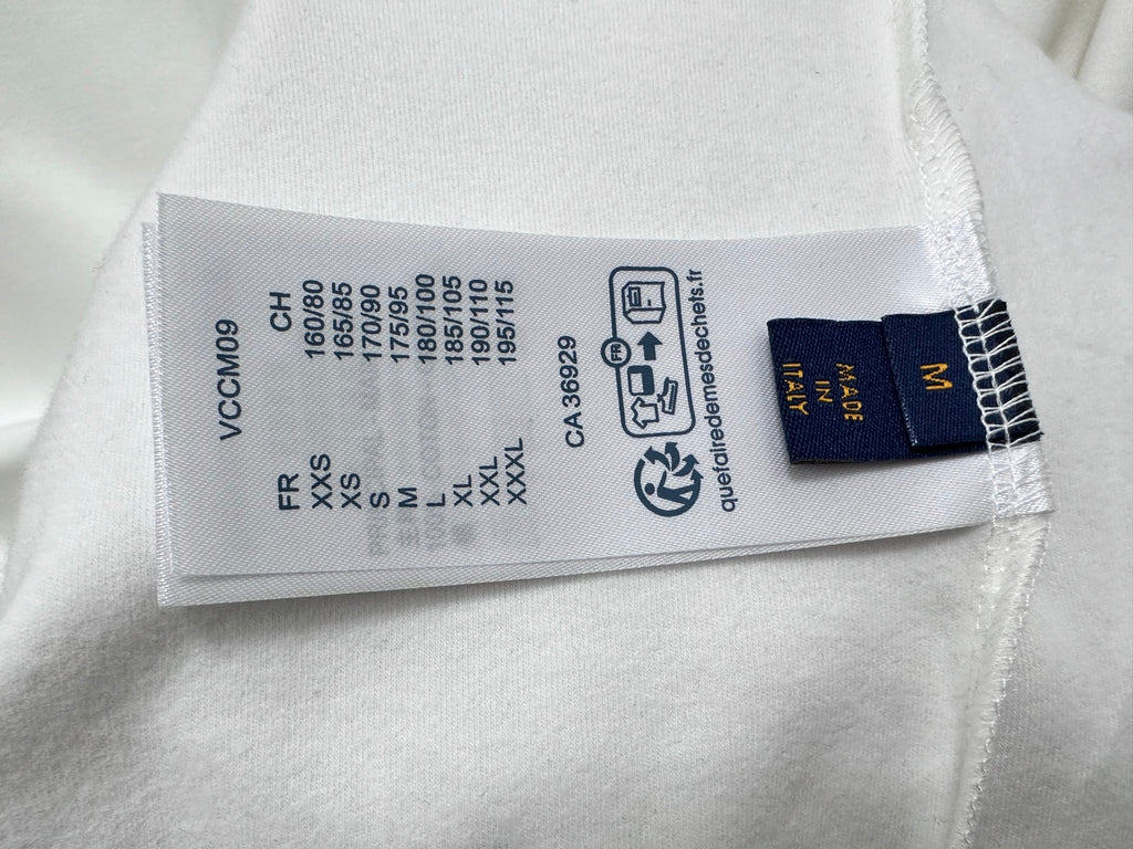 White sweatshirt with stitched size and care tag, including Louis Vuitton branding