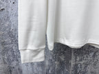 Louis Vuitton white long-sleeve crewneck shirt cropped view of lower front and hem