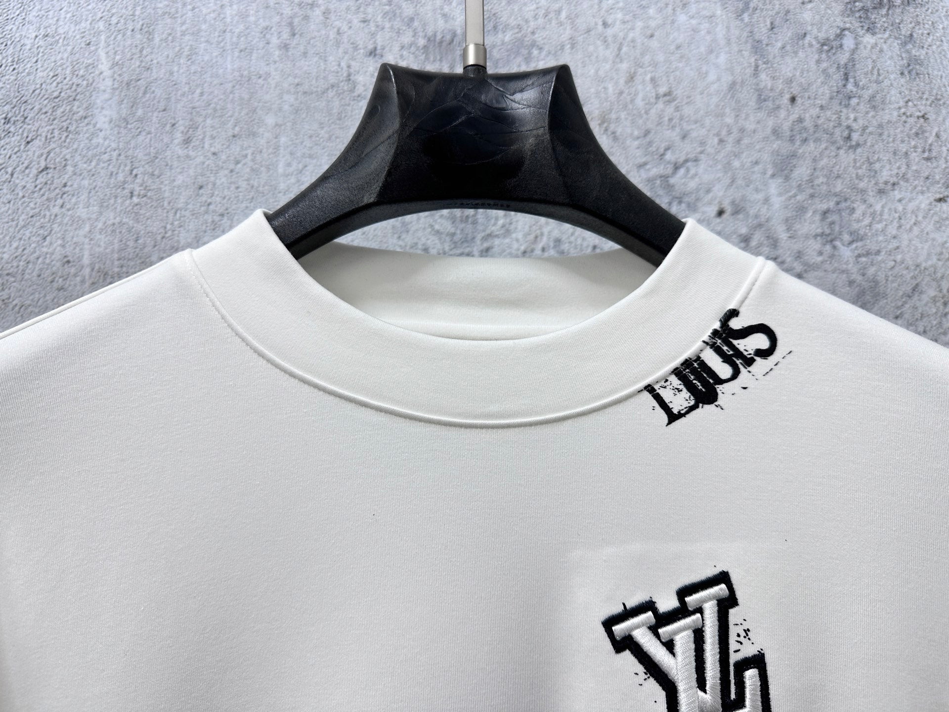 Louis Vuitton white long-sleeve crewneck shirt close-up of neckline and chest emblem