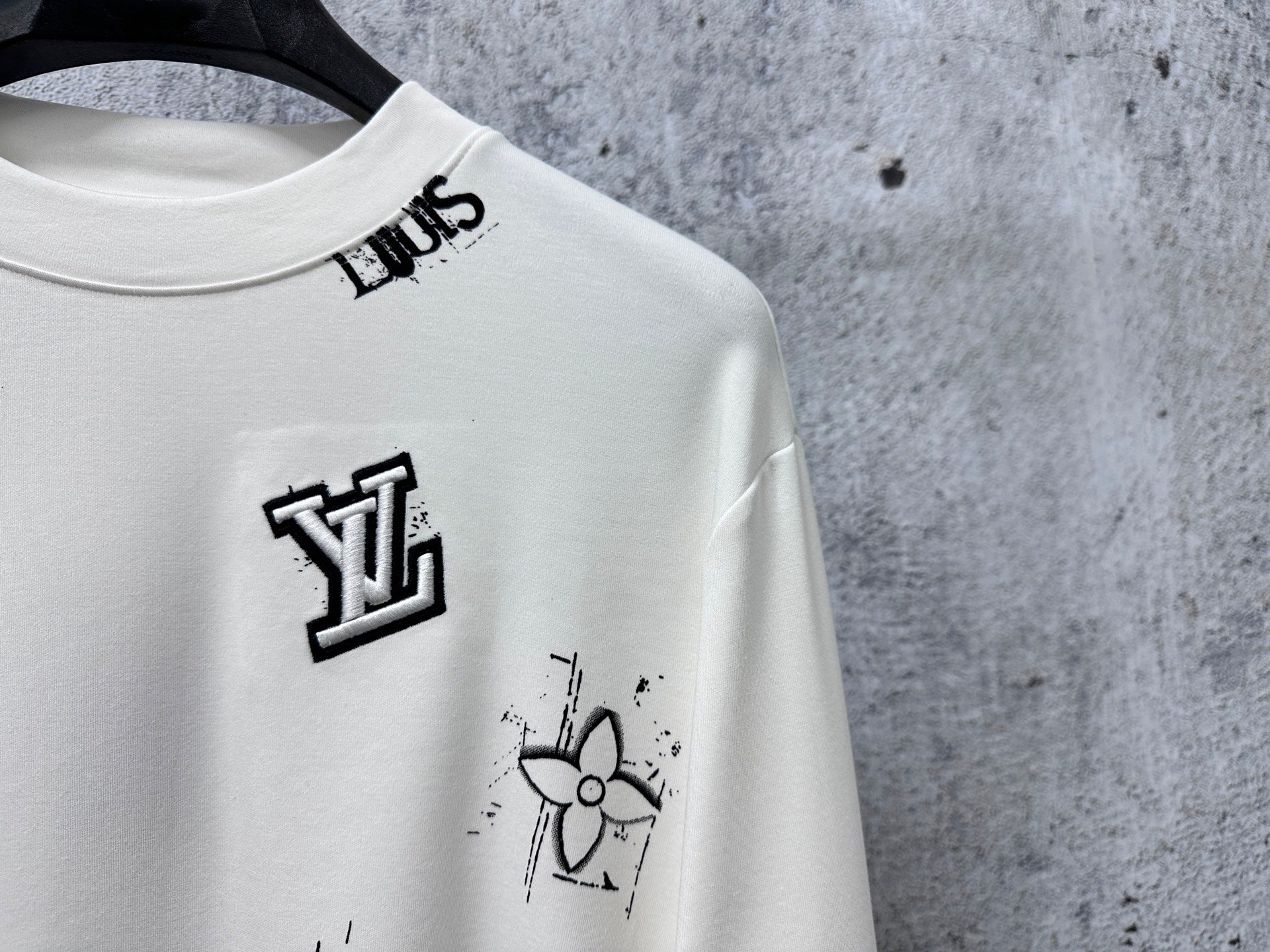 Louis Vuitton white long-sleeve crewneck shirt close-up of chest logo and graphic