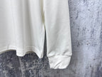 Louis Vuitton white long-sleeve crewneck shirt cropped view of lower torso and sleeves