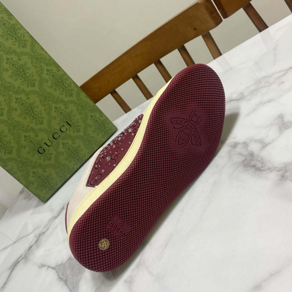 Unisex luxury sneakers by Gucci, burgundy outsole with logo and textured grip pattern.