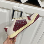 Unisex luxury sneakers by Gucci, single shoe held up: cream and burgundy studded panel.