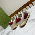 Unisex luxury sneakers by Gucci, cream uppers with burgundy heels and rhinestone detailing.
