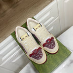 Unisex luxury sneakers by Gucci, cream lace-up with burgundy glittery quarter panels.