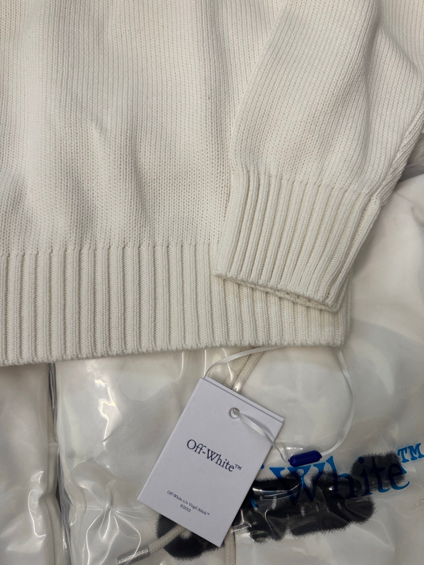 Off-White™ knit sweater sleeve and hem, off-white ribbed cuffs and knit texture