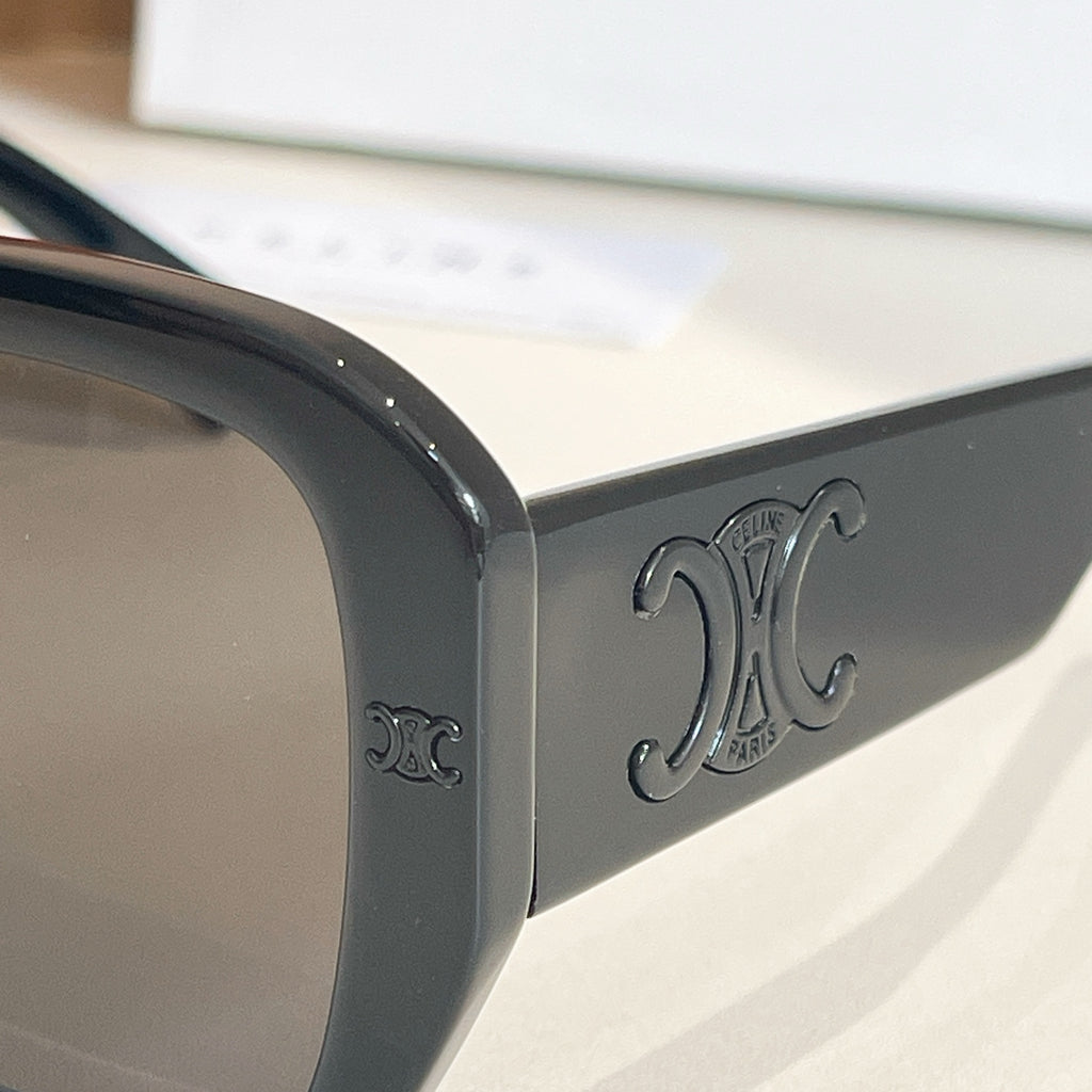 Black sunglass temple arm with embossed monogram detail