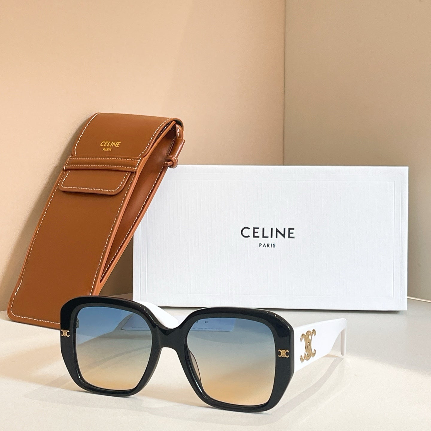 Black square sunglasses with blue-tinted lenses and signature temple detail