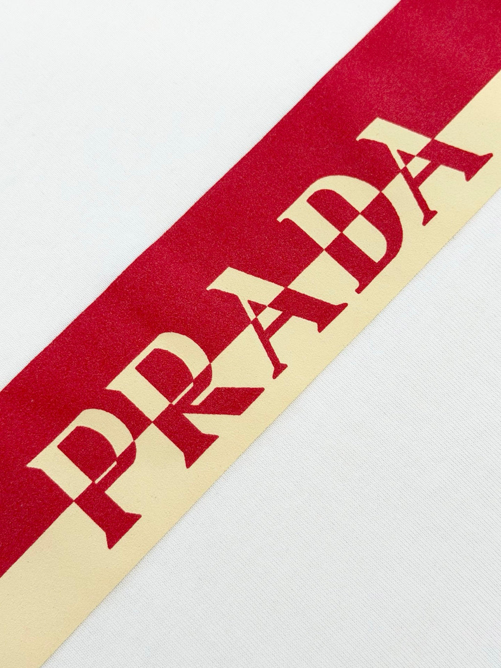 Red PRADA Milano stripe graphic across white T-shirt