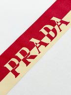 Red PRADA Milano stripe graphic across white T-shirt