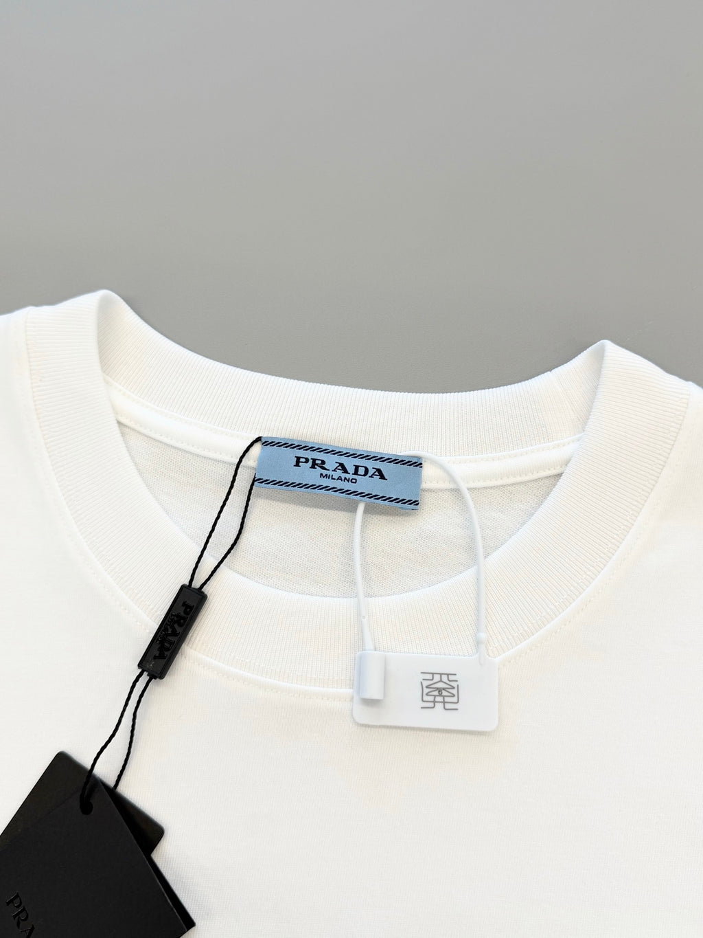 White T-shirt neckline with interior tag and attached hang tag string