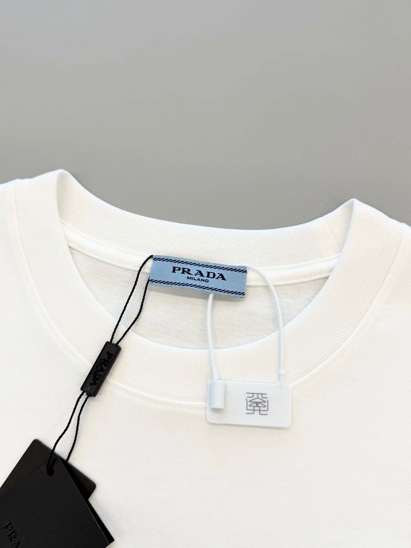 White T-shirt neckline with interior tag and attached hang tag string