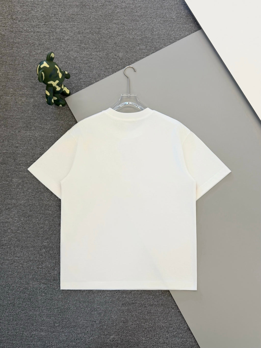White short-sleeve T-shirt on hanger with minimal chest triangle logo