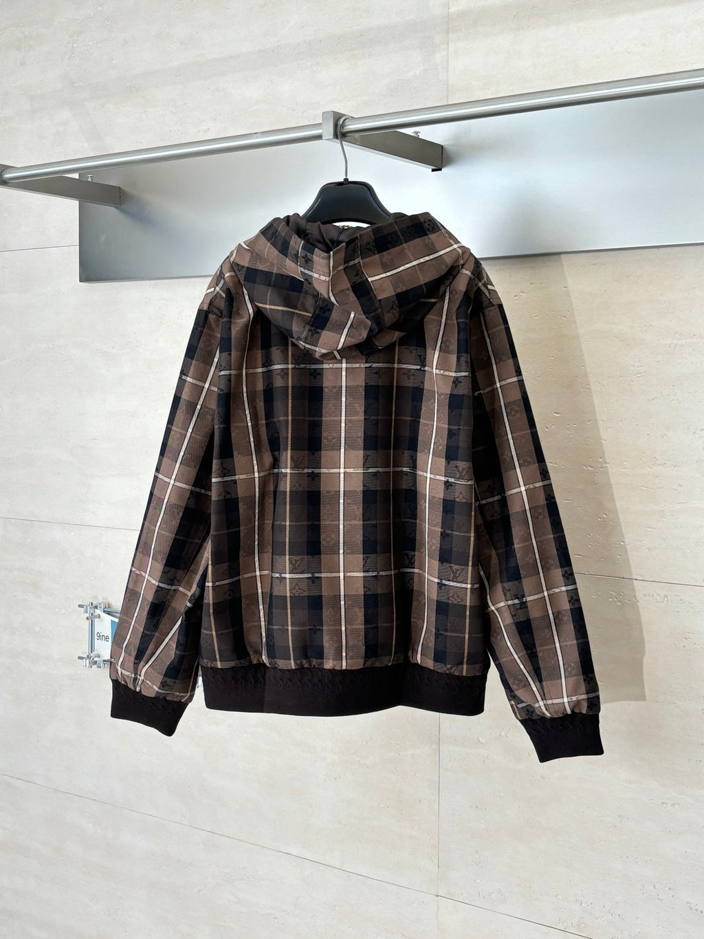 Plaid hooded zip jacket on hanger, black ribbed hem and long sleeves