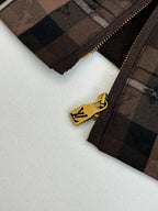 Gold-toned zipper on plaid jacket with logo pull tab